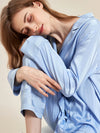 Close-up of silky blue striped sleepwear fabric and relaxed pajama styling