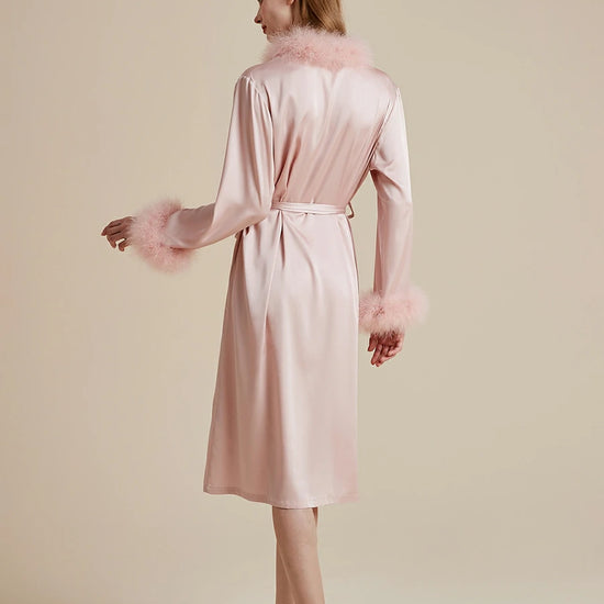 Back view of blush pink luxury satin robe with soft feather trim