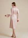 Back view of blush pink luxury satin robe with soft feather trim