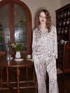 Women's luxury chain print sleepwear set beside classic wooden window interior