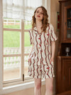 Women's vintage chain print satin pajama shorts set beside elegant window interior