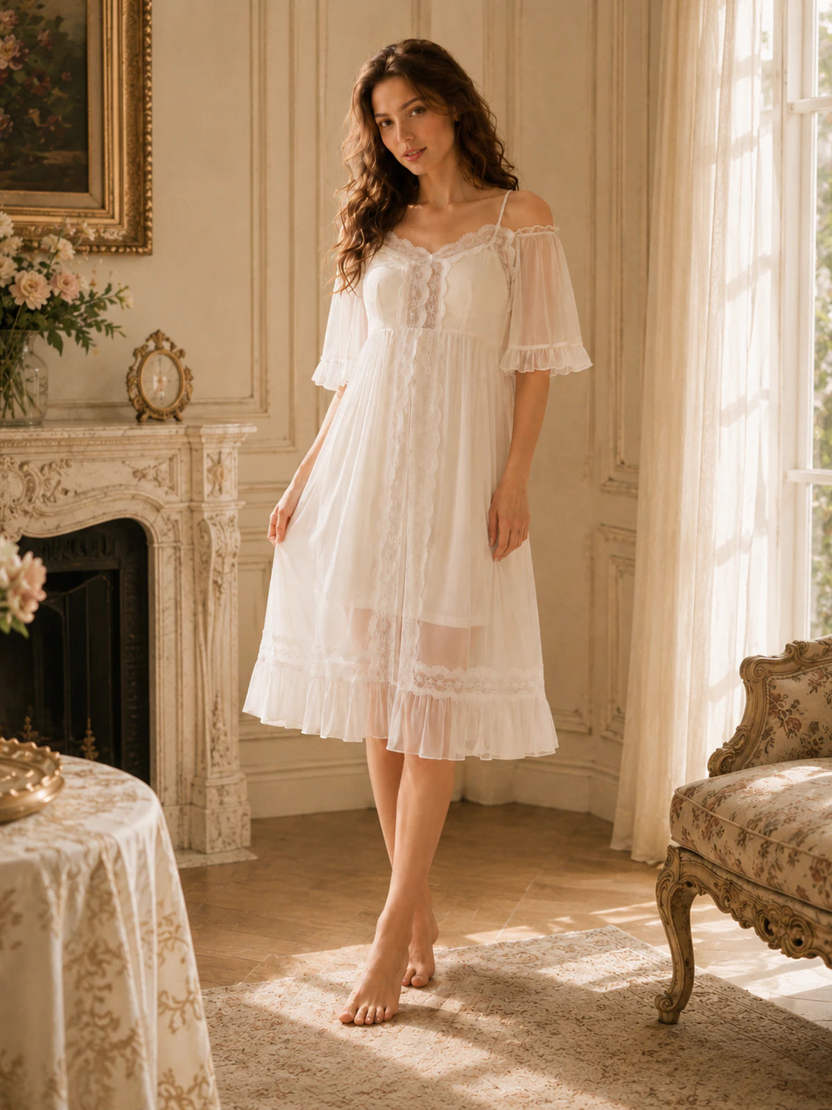 A woman stands barefoot in a sunlit classical room wearing a white off-the-shoulder lace nightgown with a ruffled hem.