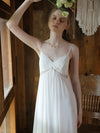 Woman wearing romantic viscose mesh slip dress in elegant wooden bedroom