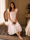 Woman sitting in SlesSic blush pink lounge dress with romantic soft girl styling