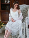Woman wearing white lace nightgown and sheer robe indoors