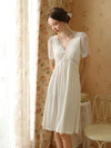 Elegant ivory viscose sleepwear dress beside floral window curtains