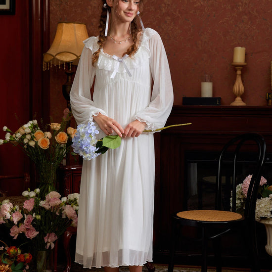 White romantic nightgown styled beside flowers, highlighting the square lace neckline and long silhouette