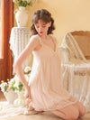 Seated view of the pink cami nightdress showing its embroidered overlay and softly flared skirt