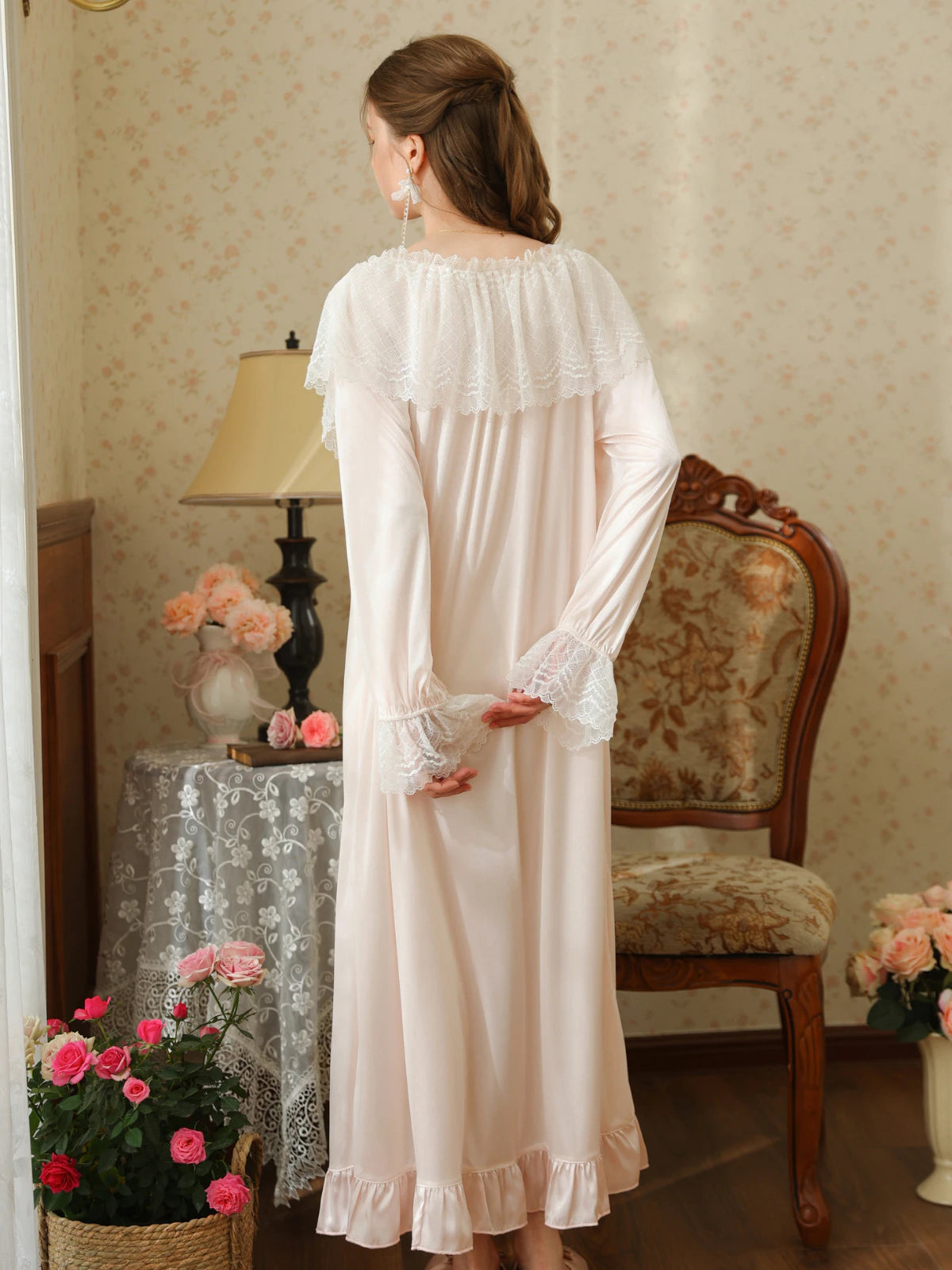 Back view of the light pink nightgown showing the scalloped lace cape collar, long sleeves, and softly gathered hem