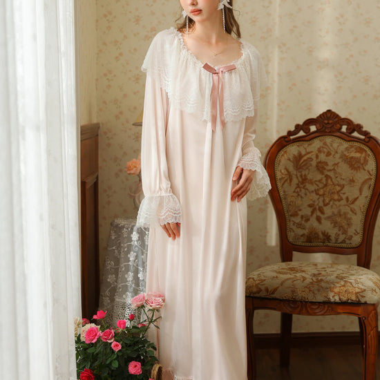 Full front view of the light pink nightgown highlighting its round lace neckline, loose silhouette, and ruffle hem