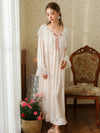 Full front view of the light pink nightgown highlighting its round lace neckline, loose silhouette, and ruffle hem