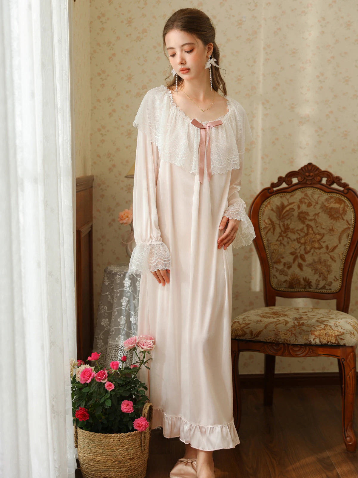 Full front view of the light pink nightgown highlighting its round lace neckline, loose silhouette, and ruffle hem