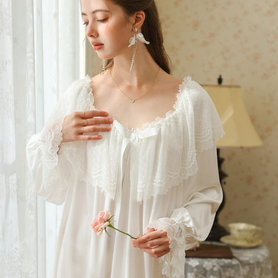 Closer front view of the white nightgown showing the layered lace cape collar, white ribbon bow, and flared lace cuffs