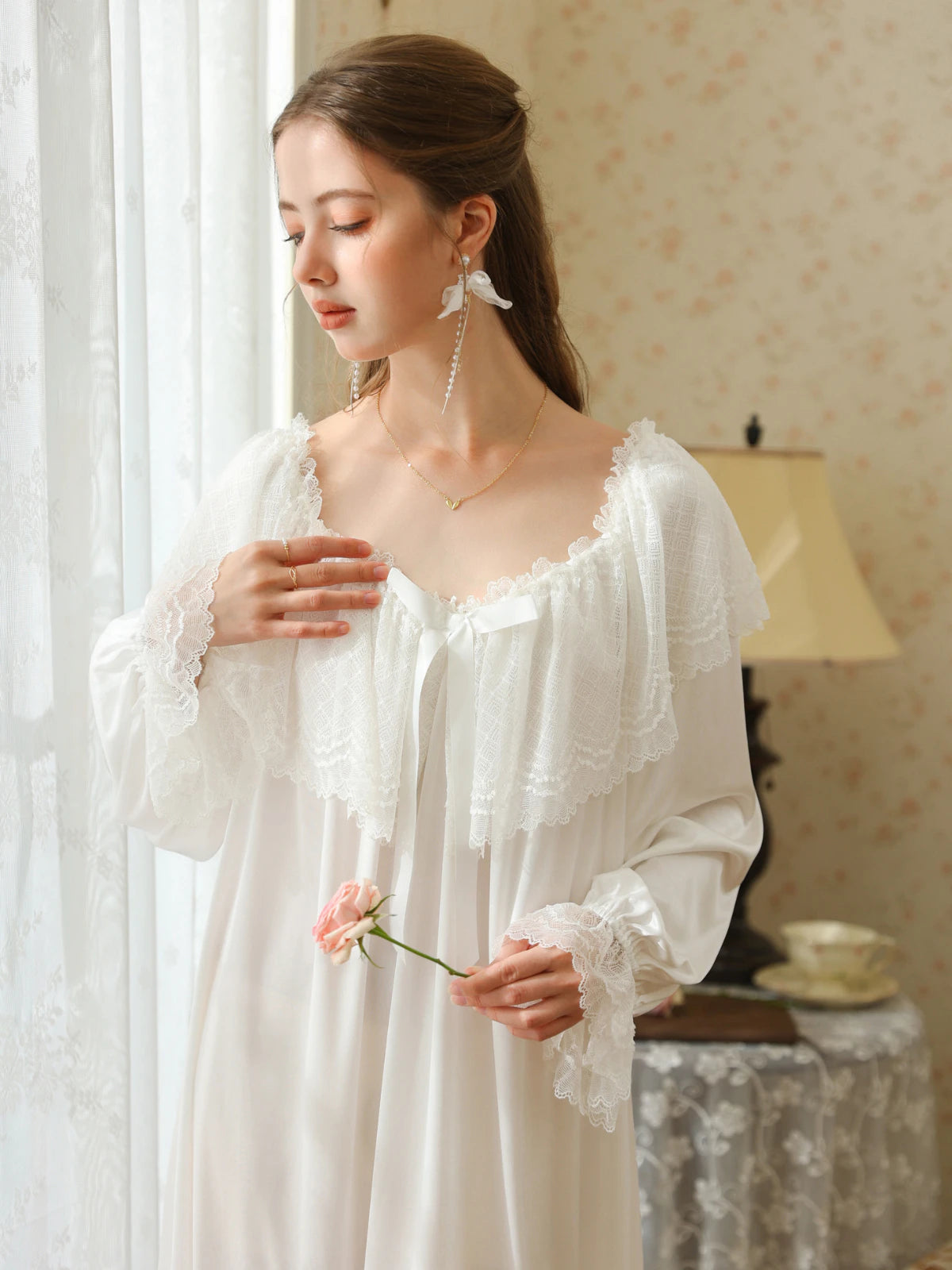 Closer front view of the white nightgown showing the layered lace cape collar, white ribbon bow, and flared lace cuffs