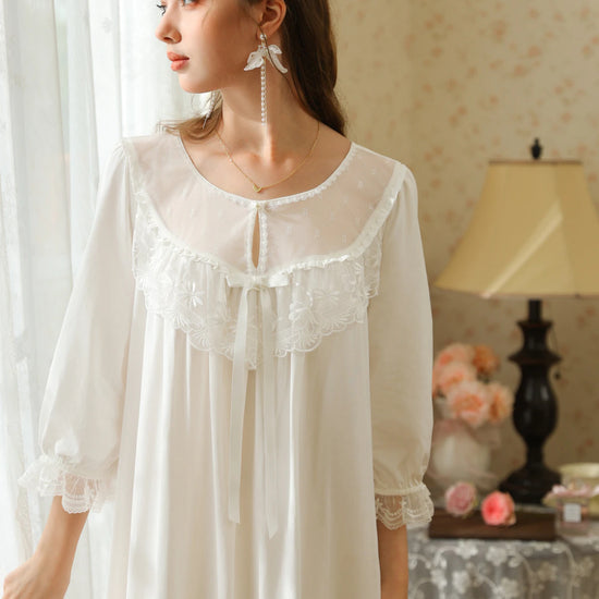 White nightgown upper front view highlighting the round keyhole neckline, floral lace bib, and gathered lace cuffs