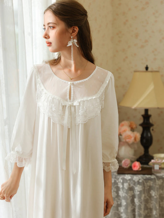 White nightgown upper front view highlighting the round keyhole neckline, floral lace bib, and gathered lace cuffs