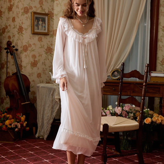 Standing angled view of the light pink nightgown showing its flowing mesh skirt and softly ruffled cuffs