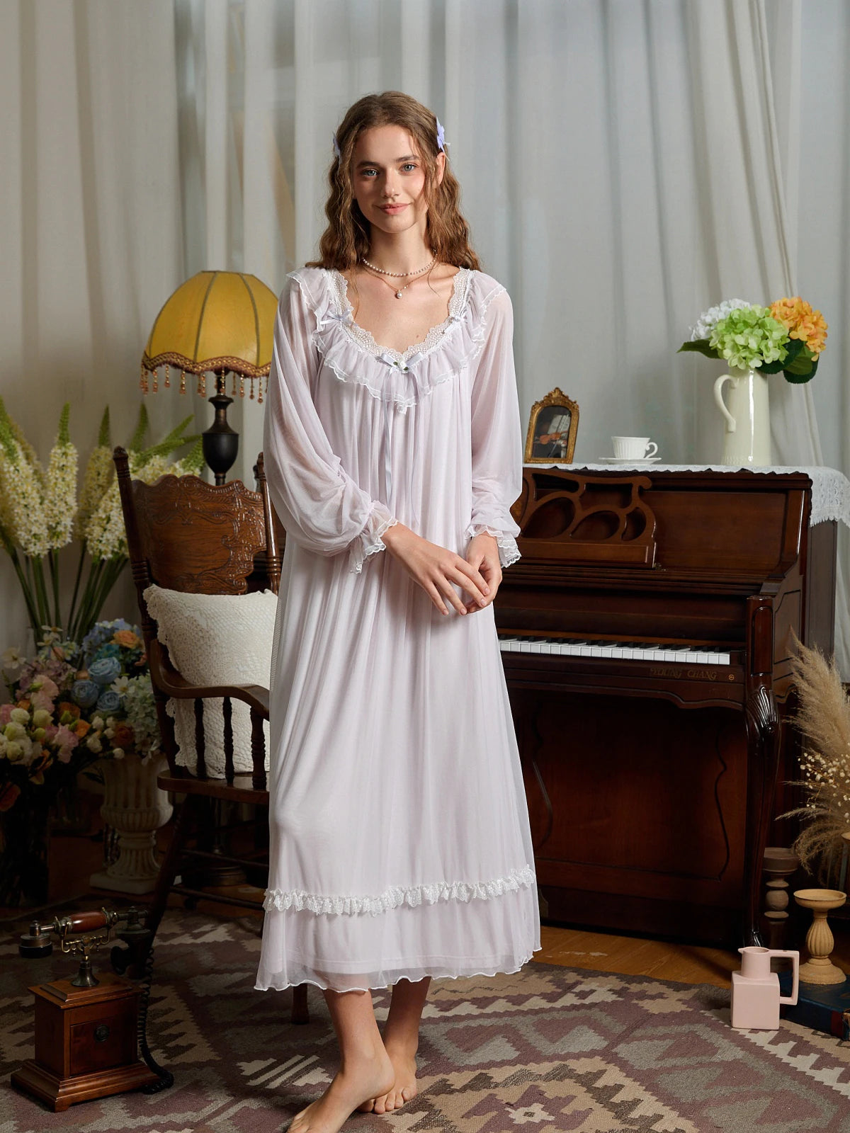 Full front view of the light purple mesh nightgown with a rose bow, long sheer sleeves, and lace-trimmed skirt