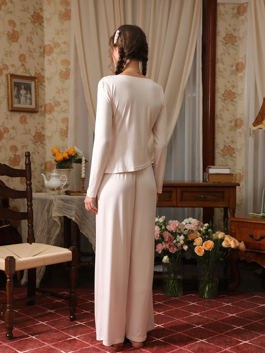Back view of the light pink pajama set showing the relaxed top and full-length wide-leg pants