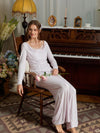 Seated view of the light purple pajama set with a draped neckline and flowing pants