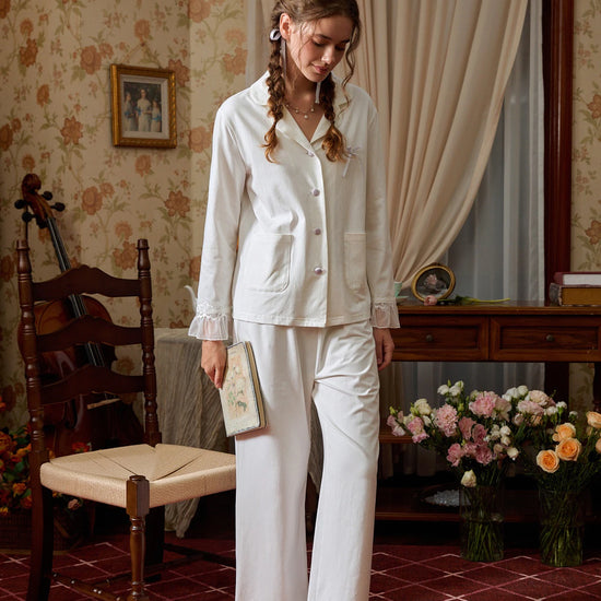 Closer view of the white button-down pajama top with covered buttons, bow, and patch pockets