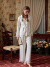 Closer view of the white button-down pajama top with covered buttons, bow, and patch pockets