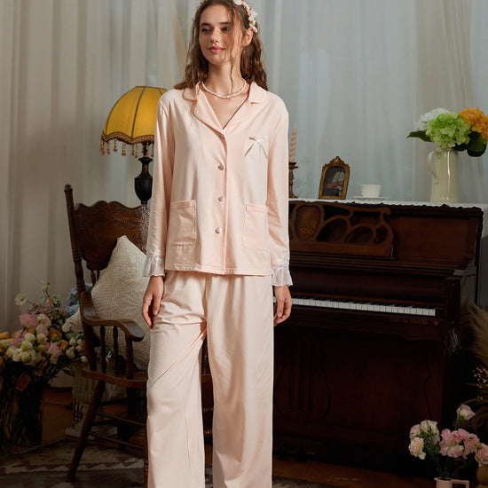 Full-length pink pajama set view showing the relaxed button-down top and ruffle hem pants