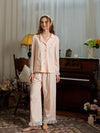 Full-length pink pajama set view showing the relaxed button-down top and ruffle hem pants