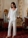 Seated view of the white pajama set highlighting the lace neckline and translucent mesh sleeves