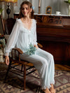 Seated light blue pajama set view highlighting floral mesh sleeves and relaxed pants