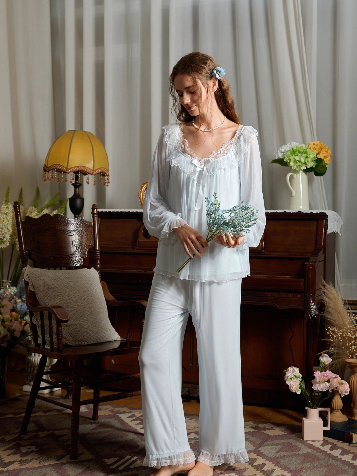 Full-length light blue pajama set styled to show its gathered cuffs and lace-trimmed pant hems