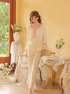 Seated view of the white pajama set highlighting the satin bow and floral lace sleeve panels