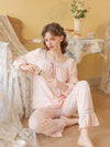 Pink square neck lace pajama set shown from the front with ribbon bow and full-length pants