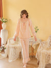 Full-length pink pajama set styled to show the gathered cuffs and ruffled pant hems