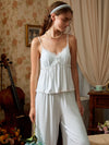 Front view of the light blue pajama cami and pants showing the lace V neckline, two satin bows, and gathered bust