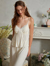 Light yellow pajama cami and pants shown from the front with slender straps, a lace V neckline, and two satin bows