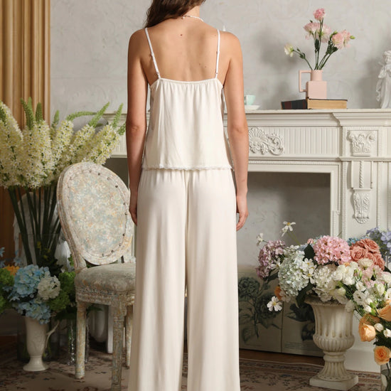 Back view of the light yellow cami pajama set showing adjustable shoulder straps, a gathered back, and wide-leg pants