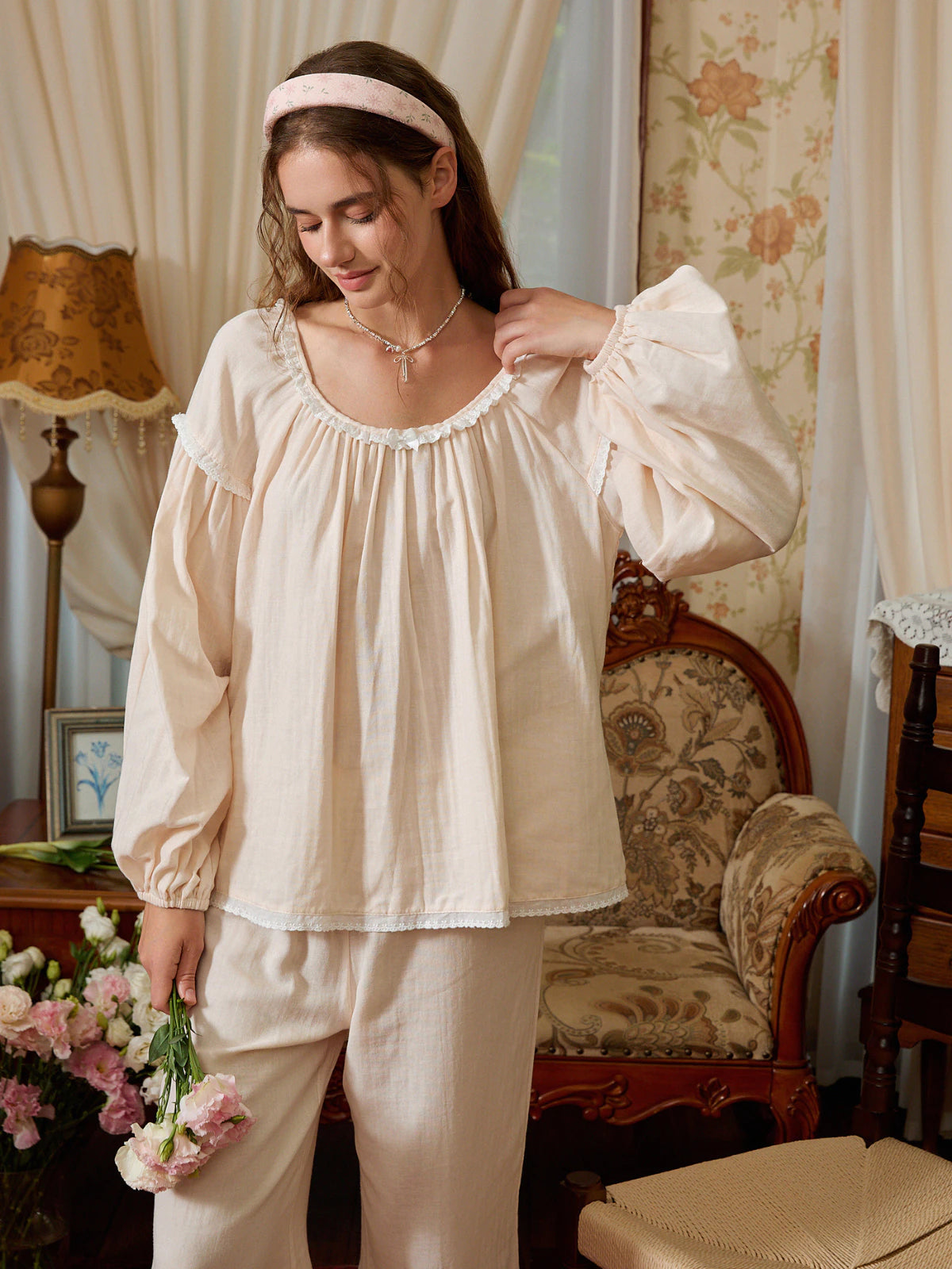 Light yellow cotton pajama top shown from the front with dropped shoulders, gathered cuffs, and scalloped lace edging