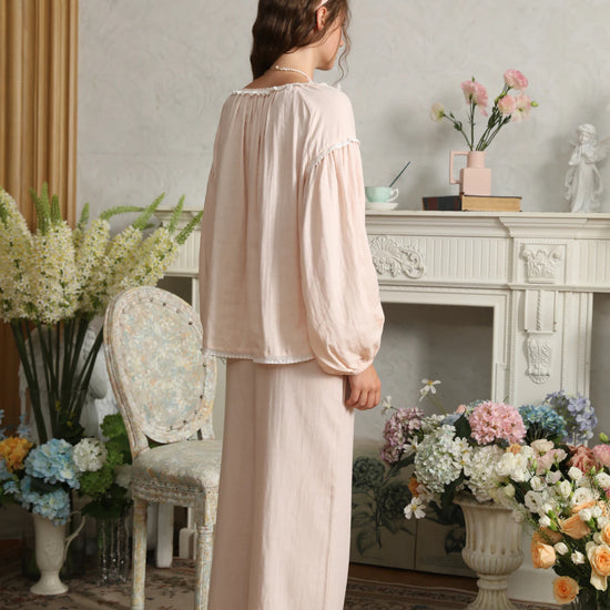 Back view of the light pink cotton pajama set showing neckline gathers, dropped sleeve seams, and relaxed pants