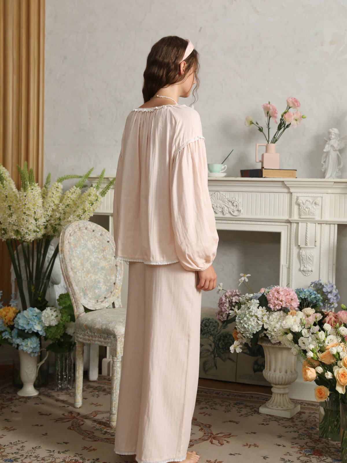 Back view of the light pink cotton pajama set showing neckline gathers, dropped sleeve seams, and relaxed pants