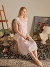 Woman sitting in SlesSic blush pink lounge dress with romantic soft girl styling